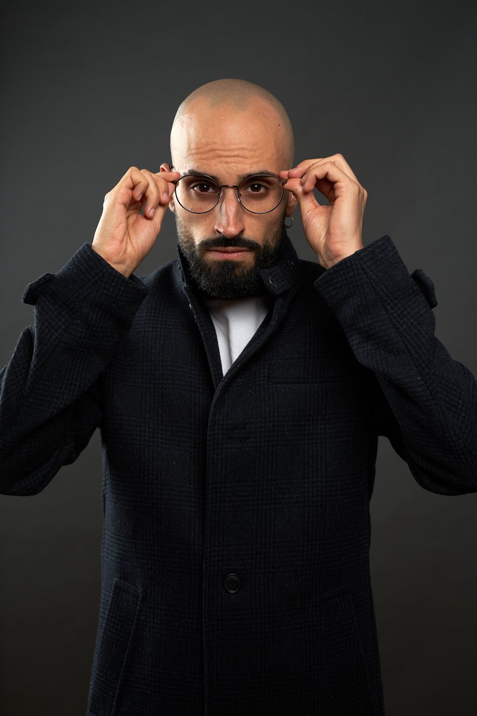 Abrigo oscuro, ajustándose las gafas